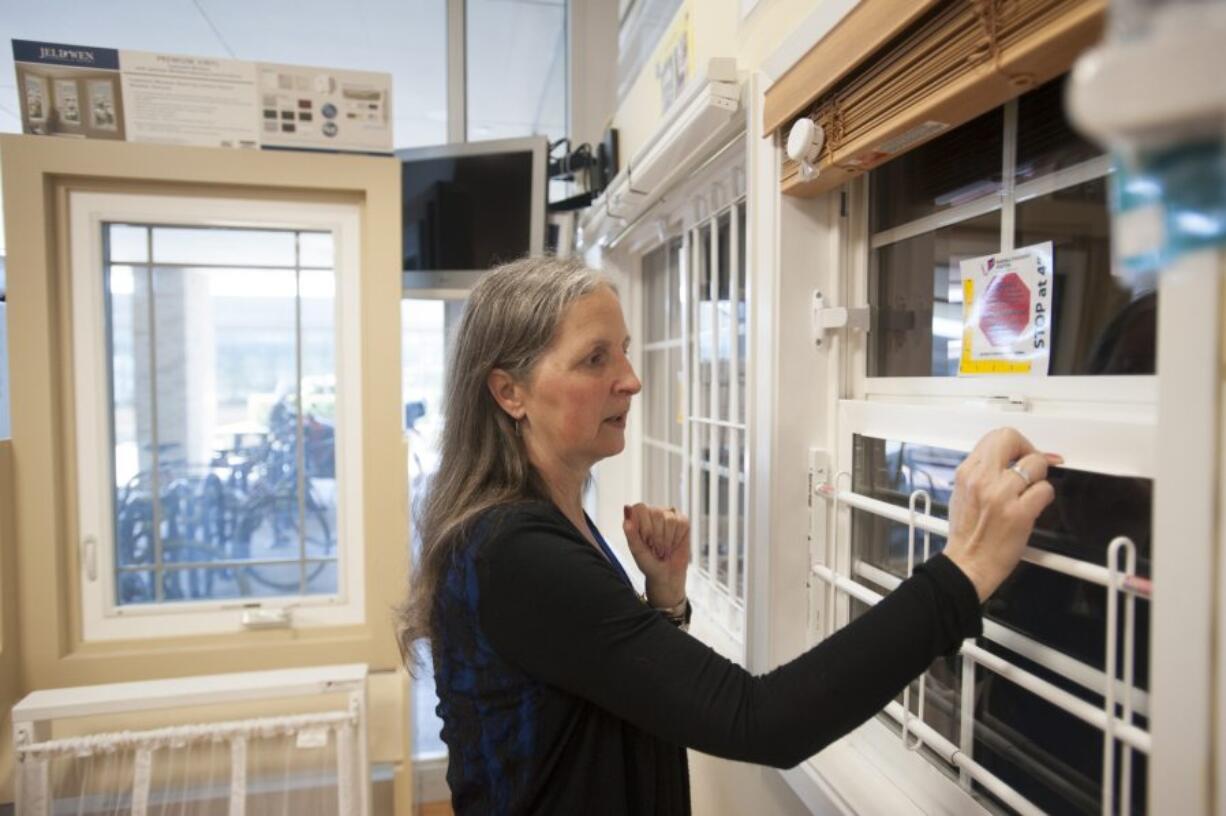 Jan Berichon, a child safety health educator at the Randall Children&#039;s Hospital Safety Center, demonstrates how window-safety devices work Wednesday afternoon at the safety center in Portland. Window stops prevent windows from opening more than 4 inches, and window guards keep children from falling out of fully open windows.