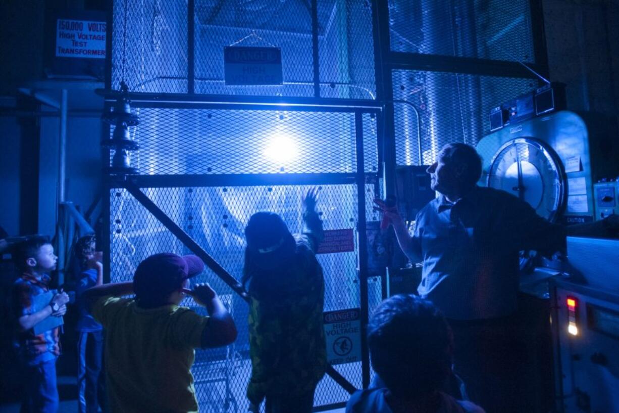 Electrical engineer Mick Johnson, right, demonstrates a corona flash Thursday at the Bonneville Power Administration&#039;s Ross Complex during Take Your Child to Work Day.