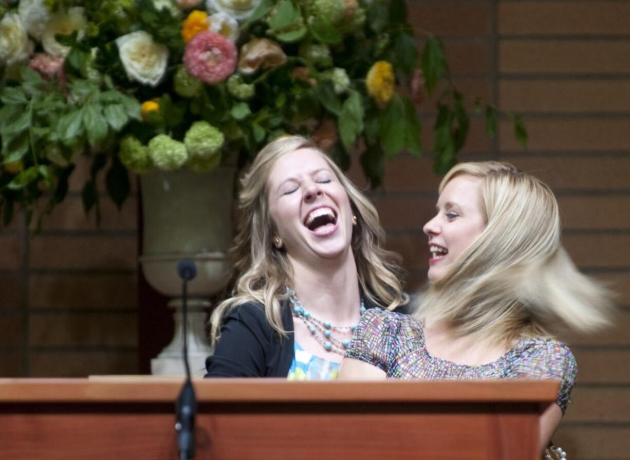 Jennifer McKibbin Harris, right, dances with her sister Megan at a memorial service for their father John McKibbin at Columbia Presbyterian Church in Vancouver on Saturday. McKibbin, one of Clark County&#039;s best-known community leader, died late last month.