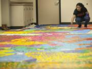 Fort Vancouver High School student Michelle Garcia, a member of the school&#039;s MEChA Club, works on a mural Monday that will be hung at the Vancouver Police Department&#039;s West Precinct building.