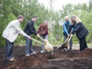 Aaron Everett of the Washington State Department of Natural Resources, from left; Vancouver Mayor Tim Leavitt; Cory Samia, the city&#039;s water and wetlands educator; urban forestry commissioner Dale Erickson; and Annette Griffy, stormwater engineering manager, plant a ginkgo tree Wednesday for Arbor Day at the Water Resources Education Center in Vancouver.