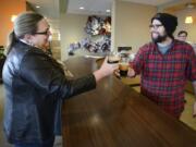 Betsy Henning, left, shares a drink with co-worker Nicholas Arnold at AHA, a Vancouver creative agency, in 2016.