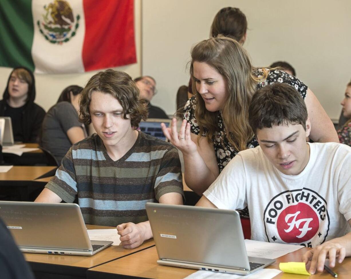 Woodland High School history teacher Katie Klaus works with junior history students Isaac Warner, left, and Matt Hambrook during a class project about World War II leaders.