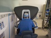 Dr. Leslie Disher, a general surgeon at The Vancouver Clinic, performs a robot-assisted laparoscopic hernia repair surgery Wednesday at Legacy Salmon Creek Medical Center. Disher operates the robot from a control console in the corner of the operating room.