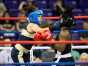 Stephanie Simon of Vancouver, left, delivers a punch to Ejakhain Obiomon of Army on her way to winning her second national college boxing title. (Kathryn S.