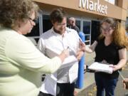 Alixandra Hunsucker, left, helps Chris Remor and April Chase, right, sign a petition that would put Initiative 1431, the so-called grandparent visitation initiative, on the November ballot. The initiative would allow a nonparent relative to petition the court for visitation with a child.