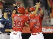 Los Angeles Angels' Mike Trout, right, celebrates his two-run home run with teammate Rafael Ortega during the sixth inning of a baseball game against the Seattle Mariners, Saturday, April 23, 2016, in Anaheim, Calif. (AP Photo/Jae C.