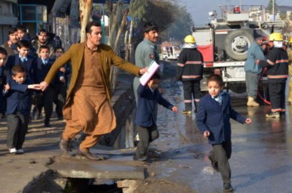 An Afghan teacher, in brown, helps school children in January run from the site of clashes near the Pakistan consulate in Jalalabad, capital of Nangarhar province, Afghanistan. One of Afghanistan's proudest achievements has been getting millions of children, especially girls, back into school since the toppling of the Taliban, but that gain is crumbling across the south and in other war-torn parts of the country. Hundreds of schools have been forced to shut down because of fighting or Taliban intimidation.