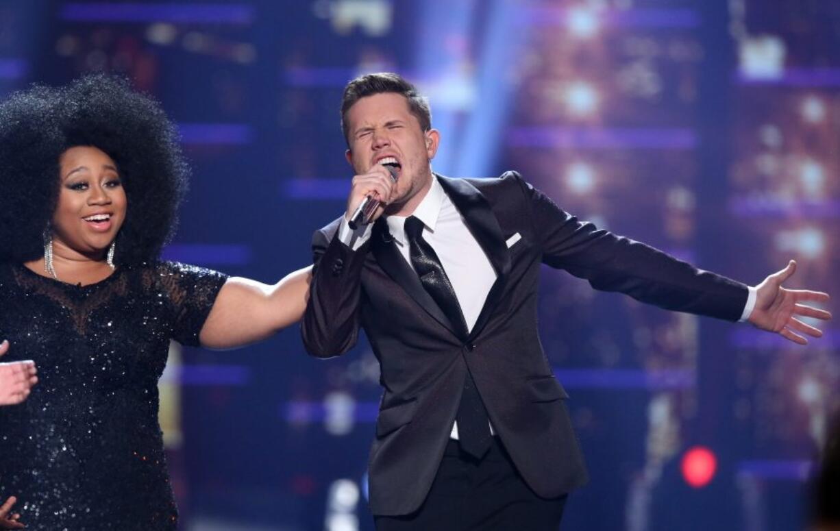 Winner Trent Harmon, right, performs Thursday at the &quot;American Idol&quot; farewell season finale at the Dolby Theatre in Los Angeles. Looking on from left is runner-up La&#039;Porsha Renae.