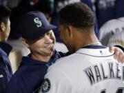 Seattle Mariners manager Scott Servais, left, embraces starting pitcher Taijuan Walker after Walker struck out the Houston Astros side in the seventh inning of a baseball game Monday, April 25, 2016, in Seattle.