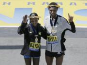 Atsede Baysa, left, and Lemi Berhanu Hayle, both of Ethiopia, pose for photos after they won the women&#039;s and men&#039;s divisions of the 120th Boston Marathon on Monday in Boston.