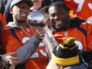 Denver Broncos cornerback Chris Harris, left, holds the Lombardi Trophy as running back C.J. Anderson looks on at a rally following a parade through downtown Tuesday, Feb. 9, 2016 in Denver. The Broncos will keep Anderson on the roster after matching Miami's four-year, $18-million offer to the running back who scored the Broncos' only offensive touchdown in Denver's victory over Carolina in Super Bowl 50.