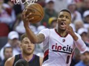 Portland Trail Blazers guard Damian Lillard (0) goes to the hoop during the second half of Game 3 on Saturday, April 23, 2016, in Portland.