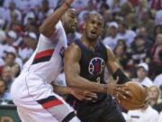 Los Angeles Clippers guard Chris Paul, right, drives to the basket past Portland Trail Blazers forward Maurice Harkless during the first half of Game 3.