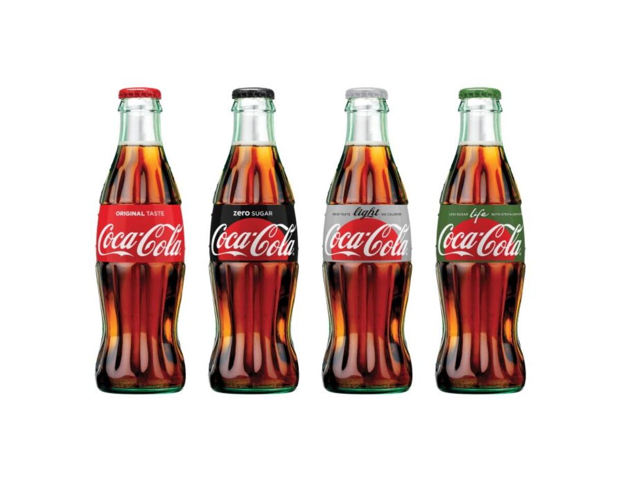 This photo provided by The Coca-Cola Company shows the new appearance of Coca-Cola bottles. Coca-Cola says it is giving cans and bottles of its flagship sodas a makeover, with plans to unify the appearance of regular Coke, Diet Coke, Coke Zero and Coke Life.