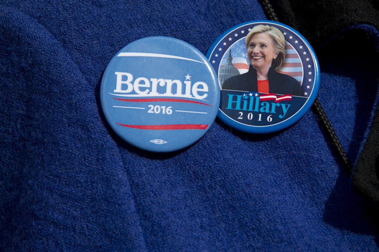 A demonstrator wears Democratic presidential candidate&#039;s Sen. Bernie Sanders, I-Vt., and Hillary Clinton buttons during a rally to condemn Republican presidential candidate Donald Trump&#039;s remarks about women and abortion in New York.