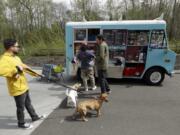 Dog owners line up at a food truck specializing in treats for their four-legged friends during the lunch hour April 5 at the headquarters for the clothing and skateboard retailer Zumiez in Lynnwood.