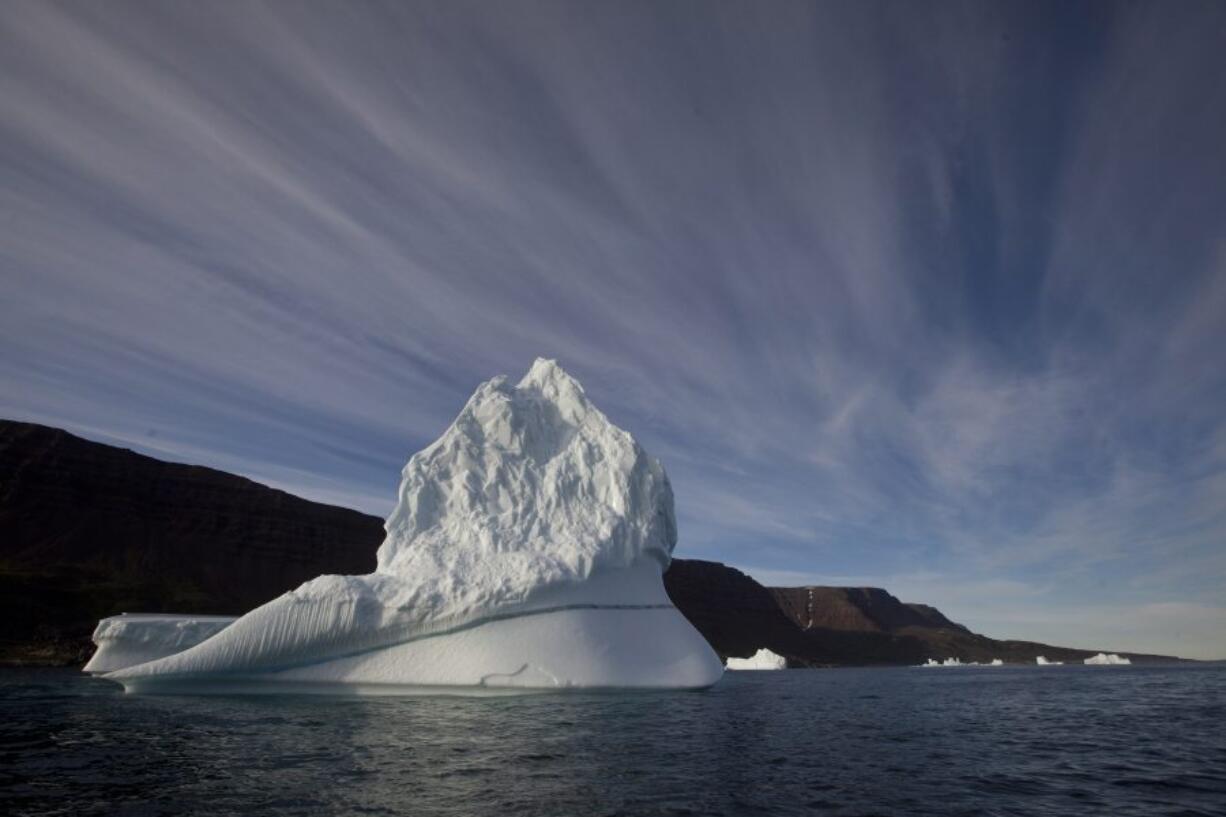 An iceberg floats July 21, 2011, in the sea near Qeqertarsuaq, Disko Island, Greenland. Global warming is shifting the way the Earth wobbles on its polar axis, a new NASA study finds. Melting ice sheets, especially in Greenland, are changing the distribution of weight on Earth. And that has caused both the North Pole and the wobble, which is called polar motion, to change course, according to a study published Friday in the journal Science Advances.