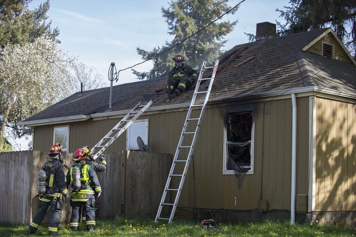 Fire crews with the Vancouver Fire Department work at the scene of a house fire Wednesday afternoon in the 3400 block of V Street in the Rose Village neighborhood. One of the house’s occupants, who was home at the time, was not injured.