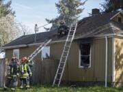 Fire crews with the Vancouver Fire Department work at the scene of a house fire Wednesday afternoon in the 3400 block of V Street in the Rose Village neighborhood. One of the house’s occupants, who was home at the time, was not injured.