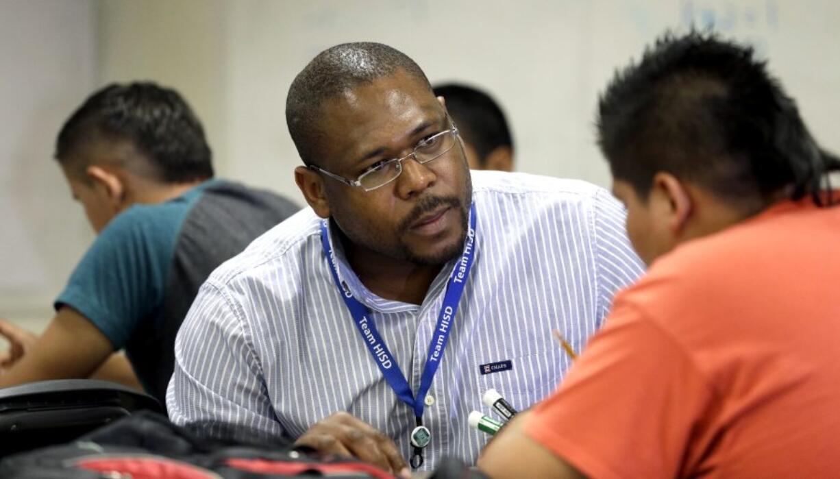 Teacher Eddison James works with students at Liberty High School in Houston.