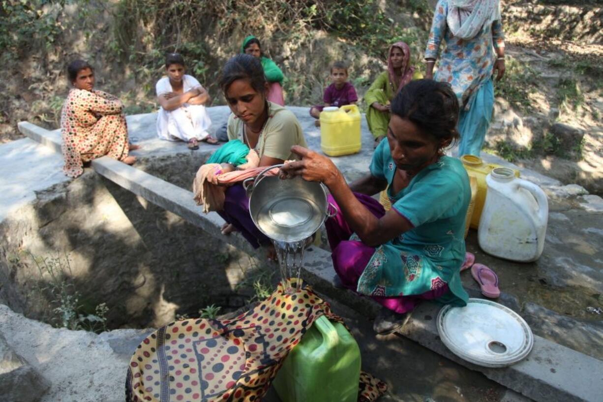 Indian village women collect drinking water Friday from a nearly dry well at Talad village in Samba district, some 25 miles from Jammu, India. Much of India is reeling under a weekslong heat wave and severe drought conditions that have decimated crops, killed livestock and left at least 330 million Indians without enough water for their daily needs.