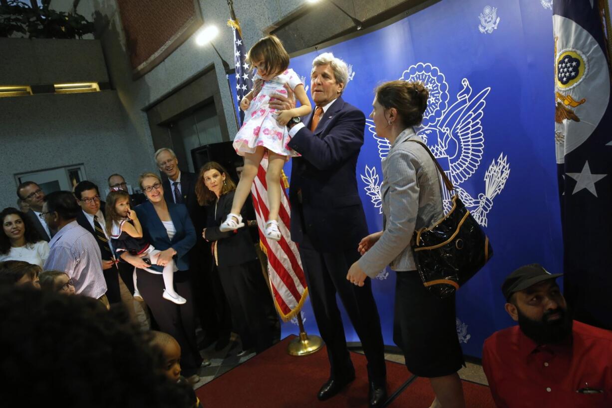 Secretary of State John Kerry hoists a child for a picture during a meet-and-greet with U.S. Embassy staff in Manama, Bahrain, on Thursday.