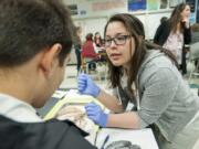 NW NOGGIN volunteer Angela Gonzalez, a neuroscience student at WSU Vancouver,  talks with Noah Tukhashvili, a Skyview High School biology student, about the parts of a sheep brain at Skyview in April 2015. Gonzalez is part of a NW NOGGIN team traveling to the nation&#039;s capital to discuss how the group develops K-12 students&#039; enthusiasm for brain science.