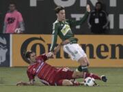 FC Dallas midfielder Ryan Hollingshead, left, and Portland Timbers forward Lucas Melano vie for the ball during the second half of an MLS soccer match in Portland, Ore., Wednesday, April 13, 2016. FC Dallas won 3-1.