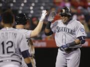 Seattle Mariners' Nelson Cruz, right, celebrates his two-run home run with Adam Lind during the 10th inning of a baseball game against the Los Angeles Angels, Friday, April 22, 2016, in Anaheim, Calif. (AP Photo/Jae C.