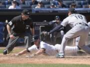 New York Yankees&#039; Brett Gardner scores on a wild pitch as Seattle Mariners pitcher Hisashi Iwakuma, right, takes the throw and home plate umpire Mike Muchlinski, left, looks on during the fifth inning of a baseball game, Sunday, April 17, 2016, at Yankee Stadium in New York.