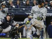 Seattle Mariners&#039; Robinson Cano follows through on an RBI single during the fourth inning of a baseball game as New York Yankees catcher Brian McCann watches, Friday, April 15, 2016, in New York.