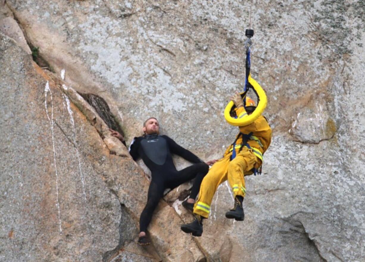 Michael Banks is stranded Thursday on a ledge some 80 feet off the ground on Morro Rock, a landmark in Morro Bay, Calif. He had scaled the rock to make an Internet proposal to his girlfriend -- who said yes -- but then got stuck on a ledge and couldn&#039;t get down. A helicopter had to be called, and Morro Bay Fire Department Capt. Todd Gailey was lowered by cable to pluck Banks and take him to safety.