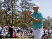 Jordan Spieth applauds on the 18th green following his first round of the Masters golf tournament Thursday, April 7, 2016, in Augusta, Ga.