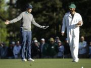 Jordan Spieth discusses his approach shot on the 15th hole with his caddie Michael Greller during the third round of the Masters golf tournament Saturday, April 9, 2016, in Augusta, Ga.