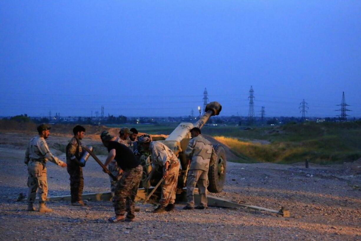 Iraqi Security forces and allied Popular Mobilization forces prepare to fire towards extremist&#039;s positions in the Islamic State group held town of Besher, during a military operation to regain control of the small town, outside the oil-rich city of Kirkuk, 180 miles north of Baghdad, Iraq.