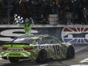 Kyle Busch celebrates after winning the NASCAR Sprint Cup Series auto race at Texas Motor Speedway in Fort Worth, Texas, early Sunday, April 10, 2016.