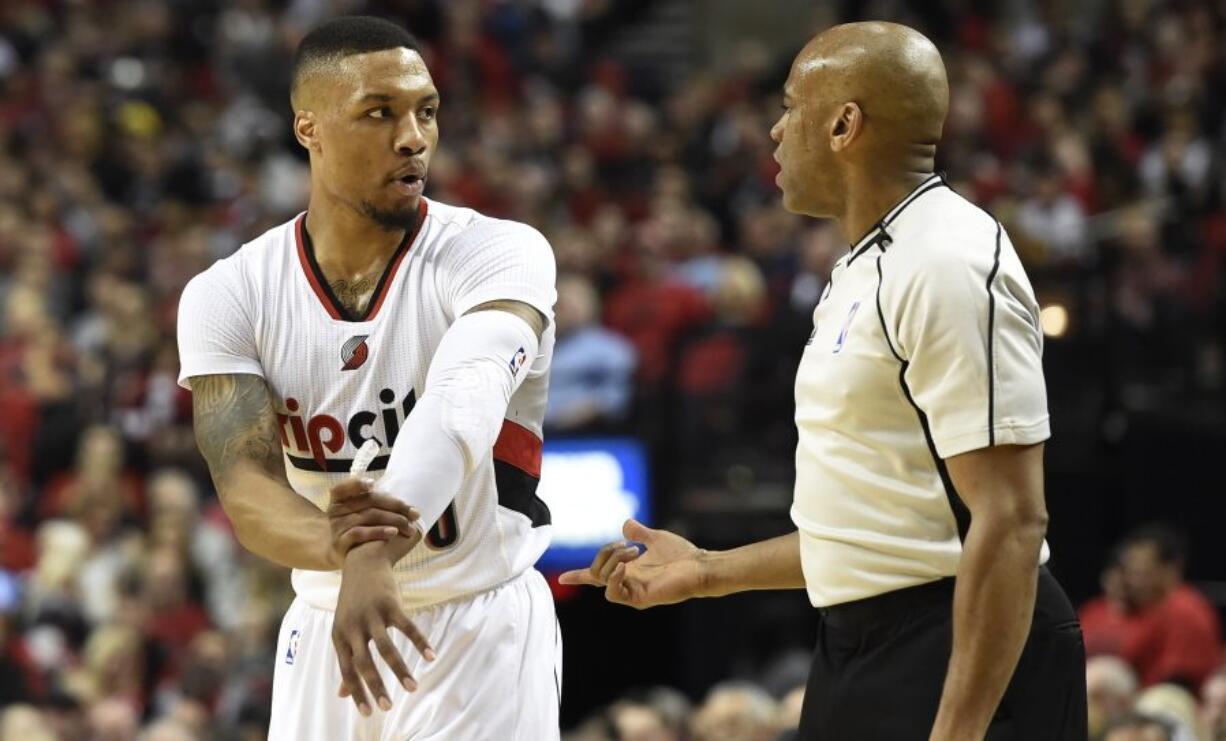 Portland Trail Blazers guard Damian Lillard (0) has some words with referee Tre Maddox (73) during the first quarter of an NBA basketball game against the Denver Nuggets in Portland, Ore., Wednesday, April 13, 2016.