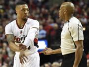 Portland Trail Blazers guard Damian Lillard (0) has some words with referee Tre Maddox (73) during the first quarter of an NBA basketball game against the Denver Nuggets in Portland, Ore., Wednesday, April 13, 2016.