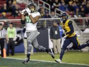 Oregon tight end Pharaoh Brown, left, catches a touchdown pass in 2014. A fluky fall, a near amputation and three surgeries later,  Brown is defying the odds and back with the Oregon Ducks.