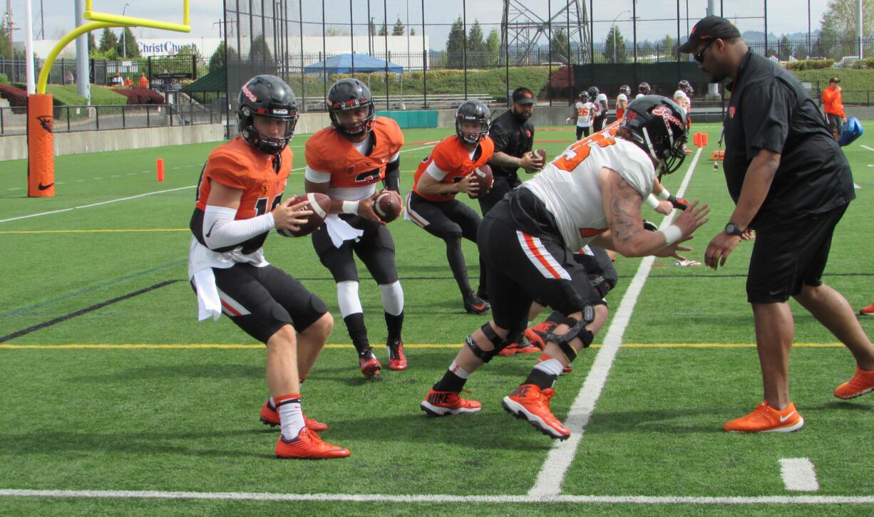 Oregon State quarterbacks Darell Garretson, left, and Marcus McMaryion practice during an spring NCAA college football training at Hillsboro Stadium in Hillsboro, Ore., Saturday, April 9, 2016. (AP Photo/Anne M.