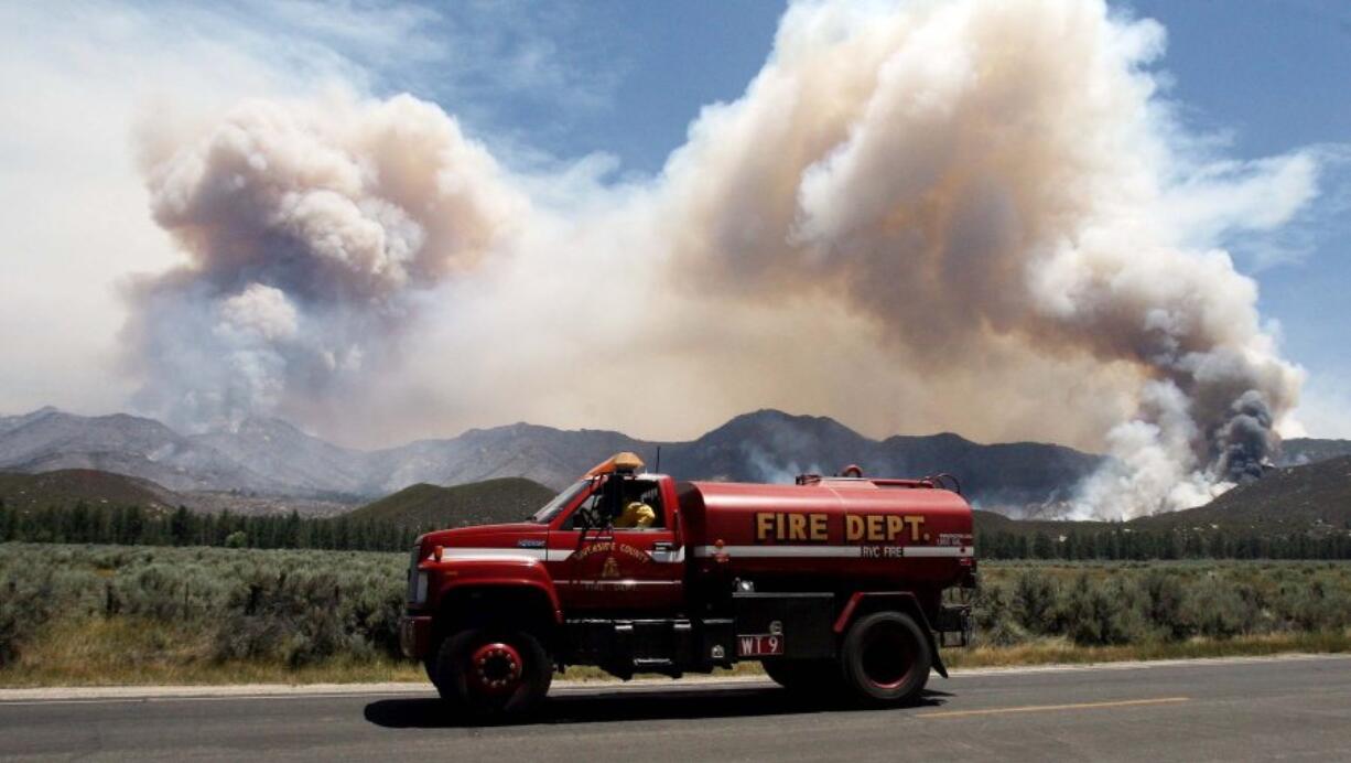 A water tender makes his way back to the 2013 Mountain Fire near Lake Hemet, Calif. Vast wildfires have created lengthy gaps in Southern California sections of the famed Pacific Crest Trail, leaving hikers to bypass via shuttles or choose alternate routes to avoid dangerous conditions such as unstable trees and loose rocks.