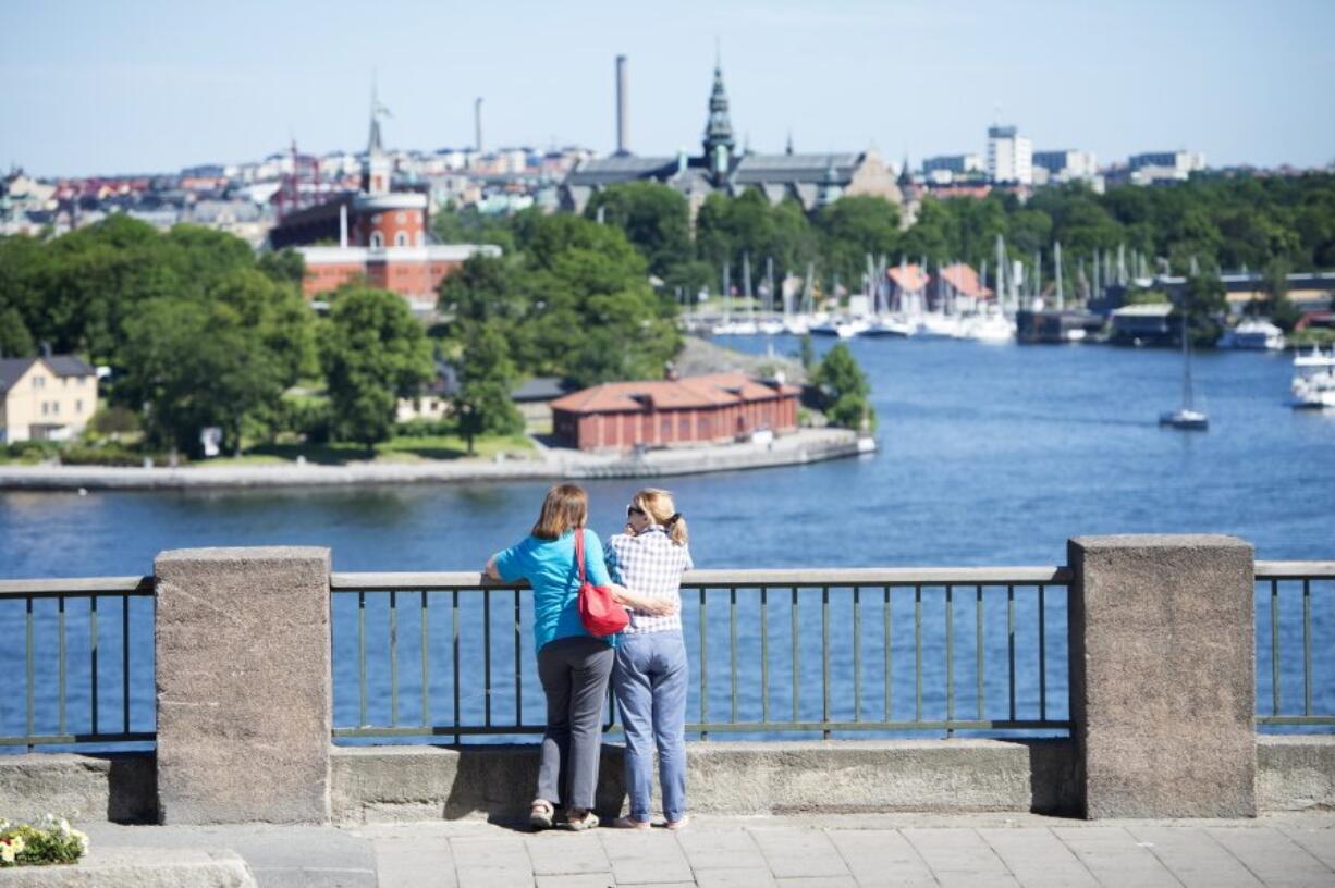 FILE - In this July 2, 2015 file photo, tourists looking at a view of Stockholm. Ever felt like calling up a complete stranger in Sweden? Now is your chance. The Swedish Tourism Association has set up a hotline that lets callers worldwide ?get connected to a random Swede.? On its website, the nonprofit group says the idea is ?to spark people?s curiosity about Sweden - our culture, nature and mindset. To help us do this, we have the people of Sweden.? About 3,000 people had dialed the ?Swedish Number? by midday Thursday, April 7, 2016 a day after it was launched, and roughly the same number of Swedes had signed up to answer calls, Ling said.