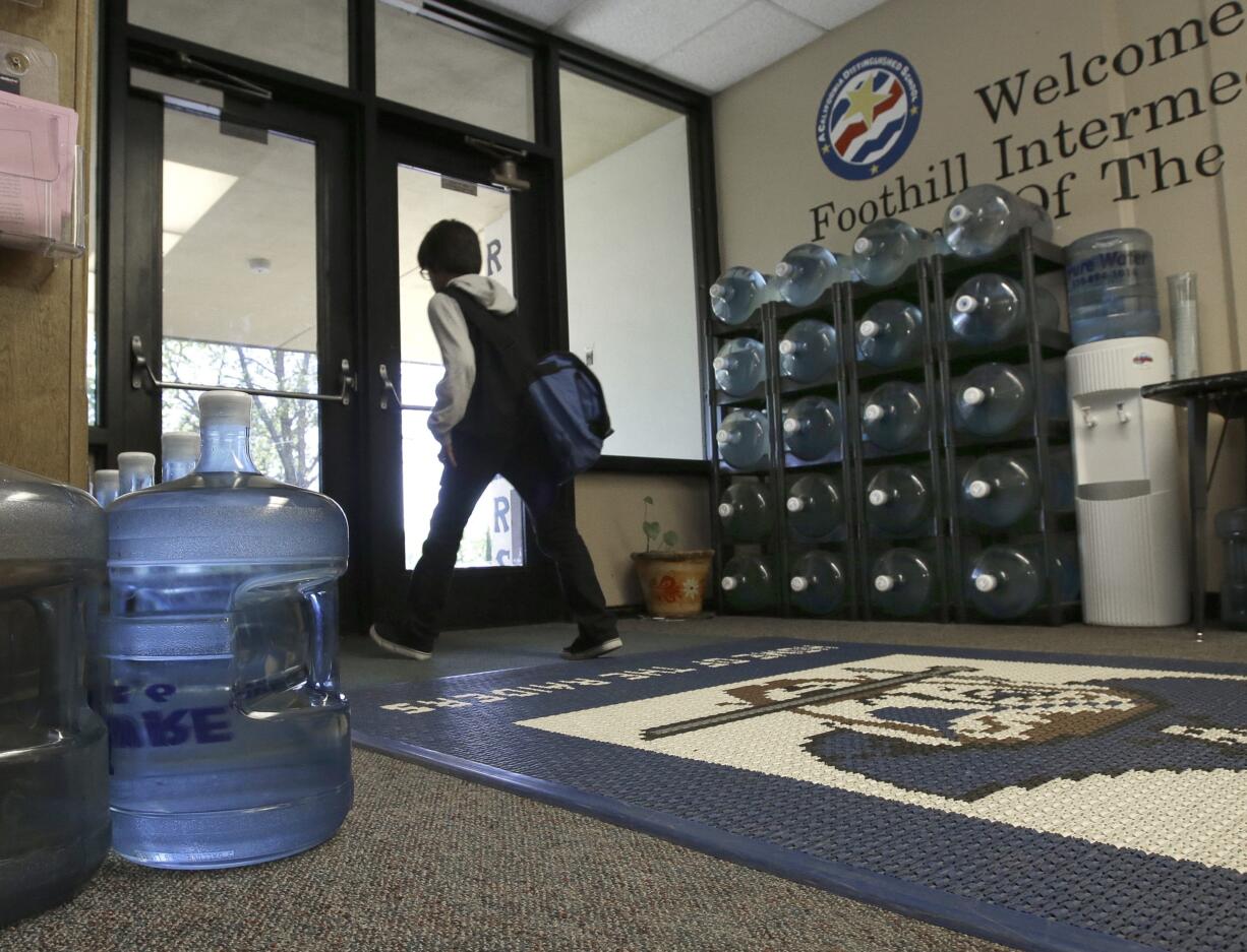 In this photo taken Wednesday, April 6, 2016 water bottles line the entrance to Foothill Intermediate School in Loma Rica, Calif. Lead in the school's drinking water frequently rises to unhealthy levels forcing district officials to haul in bottled water until they find the source of the contamination and eliminate it. Foothill Intermediate, in the Marysville Joint Union School District, is among several water systems in California and nearly 1,400 nationwide with lead levels exceeding the government's allowable levels in the last three years.