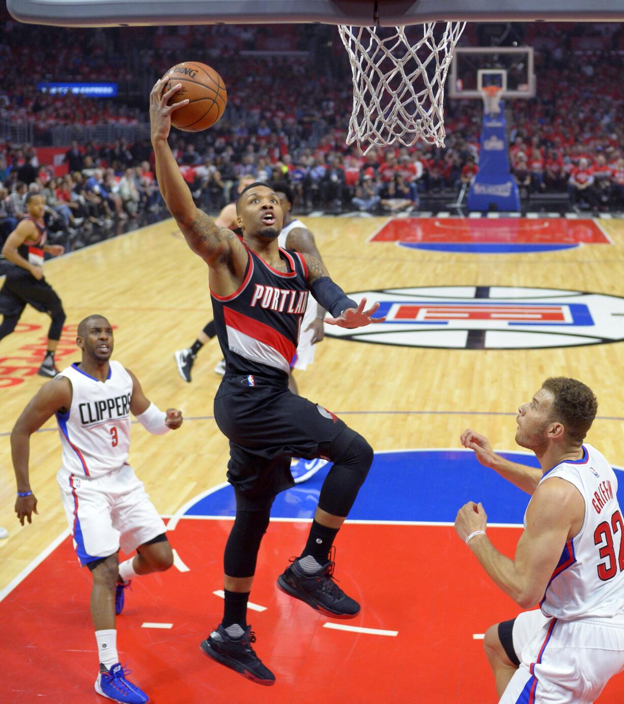 Portland Trail Blazers guard Damian Lillard, center, shoots as Los Angeles Clippers guard Chris Paul, left, and forward Blake Griffin defend during the first half in Game 2 of a first-round NBA basketball playoff series, Wednesday, April 20, 2016, in Los Angeles. (AP Photo/Mark J.