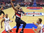 Portland Trail Blazers guard Damian Lillard, center, shoots as Los Angeles Clippers guard Chris Paul, left, and forward Blake Griffin defend during the first half in Game 2 of a first-round NBA basketball playoff series, Wednesday, April 20, 2016, in Los Angeles. (AP Photo/Mark J.