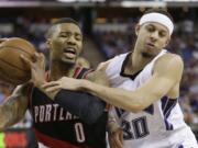 Portland Trail Blazers guard Damian Lillard left, is fouled by Sacramento Kings guard Seth Curry during the second half of an NBA basketball game Tuesday, April 5, 2016, in Sacramento, Calif. The Trail Blazers won 115-107.