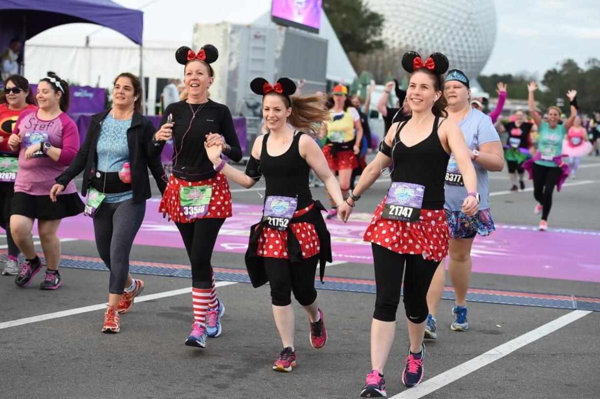 Costumed runners participate in a race at Walt Disney World in Lake Buena Vista, Fla. Many runners dress up for the popular half-marathons at Disney, where photo ops with costumed characters are as important as race times.