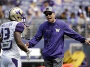 Washington head coach Chris Petersen, right, talks with Chico McClatcher at the team's annual spring preview football event Saturday, April 23, 2016, in Seattle.