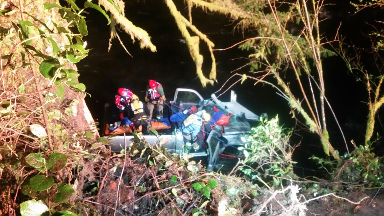 Seventeen firefighters worked to free the driver of a pickup that crashed down a 50-foot embankment Sunday night.